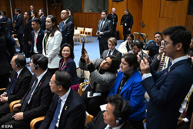 Ms Lei (pictured sitting and looking to her right) was hidden from view of television cameras by Chinese media officials (pictured far right)