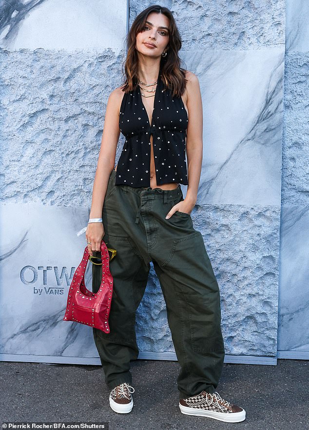 It's been a busy week for Emily, who showed off her abs in a black crop top with silver studs while attending a Vans event in Paris on Friday (pictured).