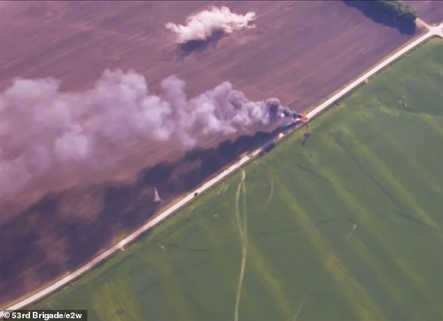 Smoke billows from the defeated convoy just two miles from the Ukrainian border.