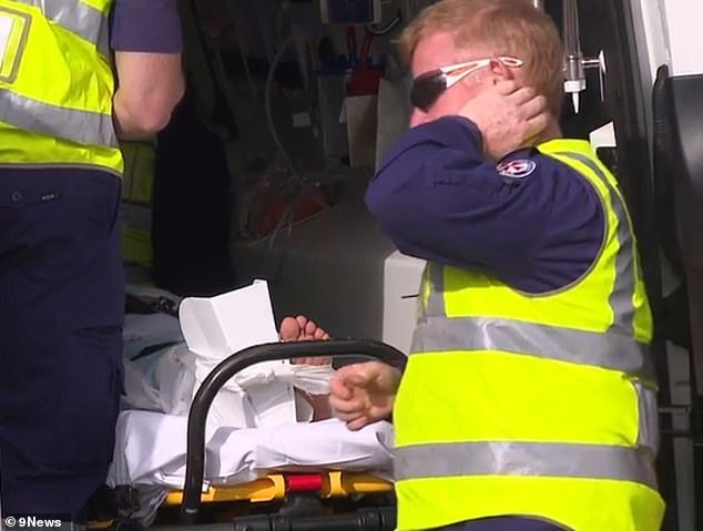 Incredibly, the car missed the stroller by inches and the baby was unharmed, but the woman fell to the ground with a broken leg (pictured in an ambulance)