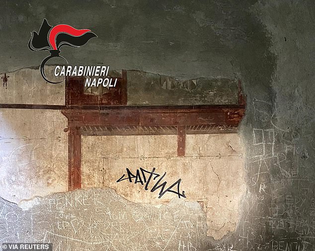 A sign made with a black marker on the wall of a domus in the Herculaneum Archaeological Park, in Ercolano, Naples, Italy