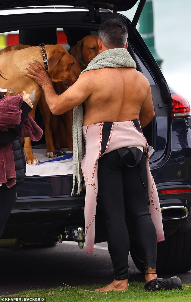 Jamie appears carrying his dogs in the back of his car.