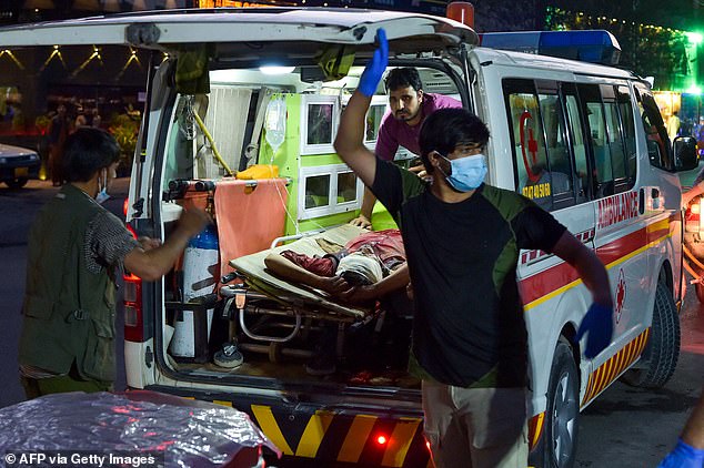 Medical staff transport an injured man to a hospital in an ambulance after two powerful explosions, which killed at least six people, outside Kabul airport on August 26, 2021.