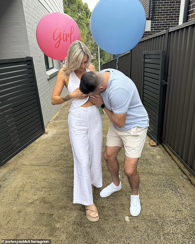 The first sees Josh kiss Ciarne's belly (pictured), while the second sees the pair happily posing against a fence while holding a pink balloon.