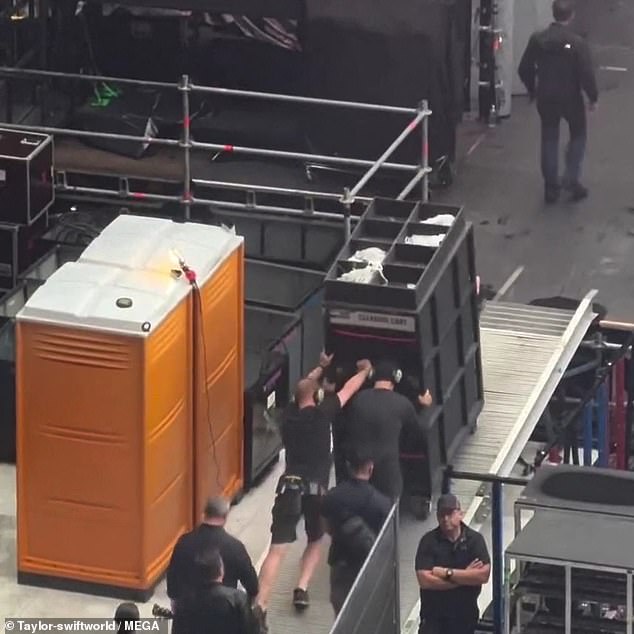 Two handsome security guards have been filmed pushing the 6ft container as Lady Gaga's song Applause fills the stadium.