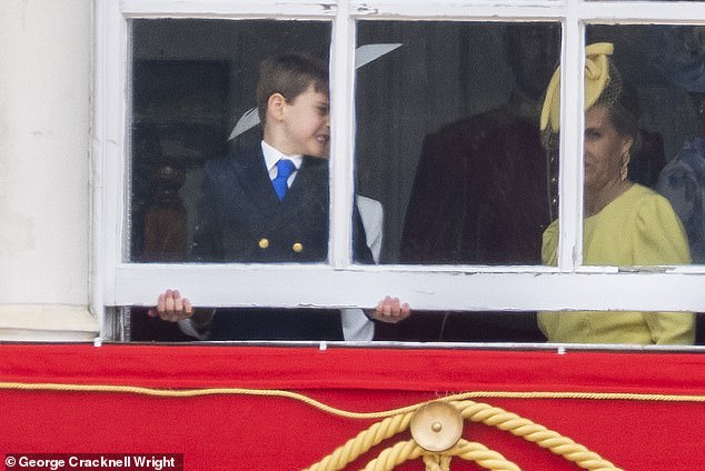 In the photo, Prince Louis tries to open a window on a balcony on Horse Guards Parade alongside the Duchess of Edinburgh.