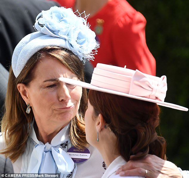 Carole Middleton affectionately put her arm around Eugenie, who wore her hair up, revealing her unusual tattoo.