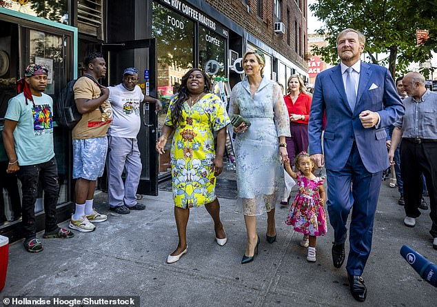 The Dutch royal couple were photographed enjoying a walk around the neighborhood with local residents dressed in equally colorful outfits.