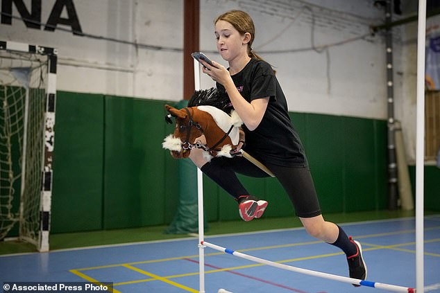 A girl jumps during a training session at a horse riding competition in Russia in April.