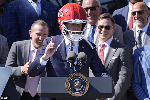 President Biden addresses the crowd wearing a signed Kansas City Chiefs helmet.