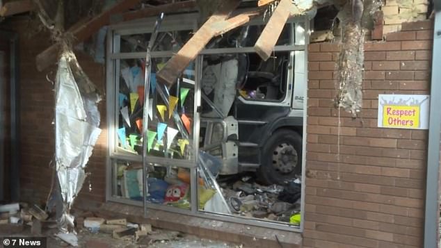 Emergency crews worked to free the trapped truck driver after he crashed into a classroom at St Joseph's Catholic Primary School in Moorebank (pictured)