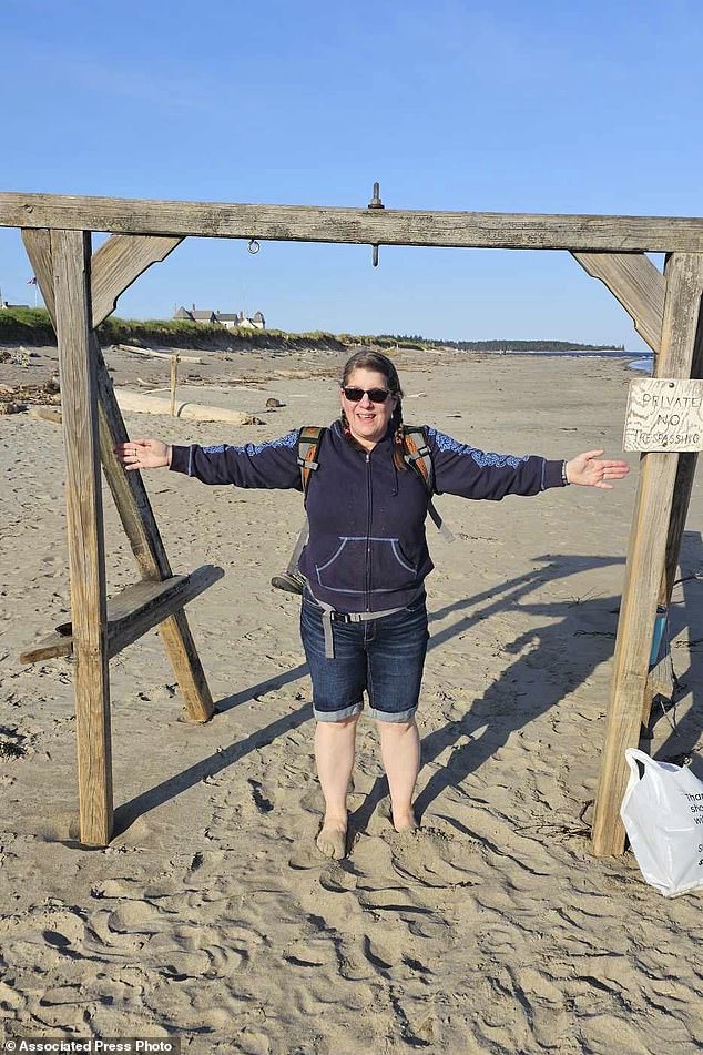 This photo provided by Patrick Acord shows his wife, Jamie Acord, at Popham Beach in Phippsburg, Maine, where she sank hip-deep in quicksand, Saturday, June 1, 2024.