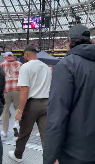 Swift can be seen performing in a red dress as Kelce headed to the VIP area.