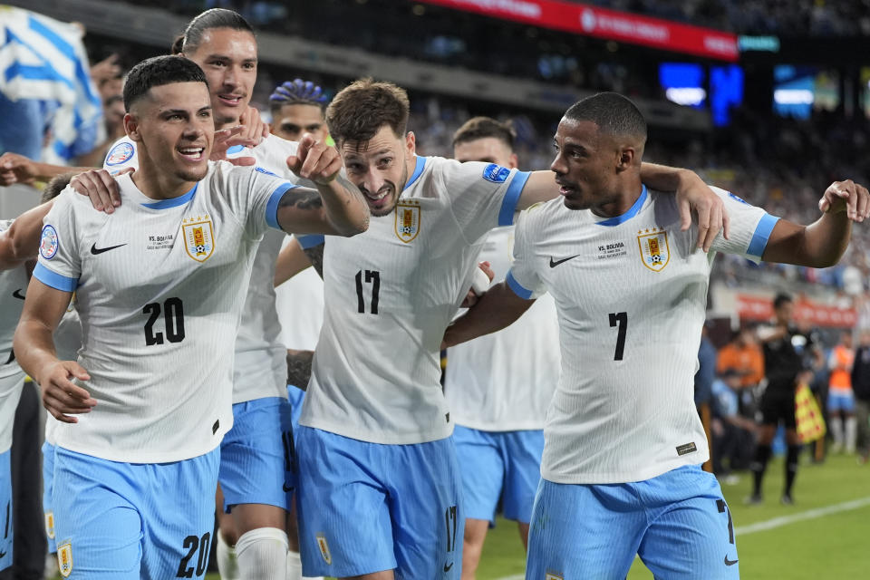 Uruguay's Maximiliano Araujo, left, celebrates with teammates after scoring his team's third goal against Bolivia during a Copa America Group C soccer match in East Rutherford, N.J., Thursday, June 27, 2024. (AP Photo/Julia Nikhinson)