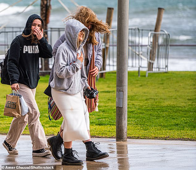 For parts of South Australia and Western Australia, the high pressure system will likely bring rain for longer periods than normal (pictured, people walking on Henley Beach, Adelaide)