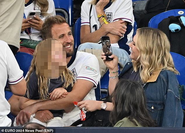 Katie Kane takes a photo of captain Harry Kane posing with his son after the match