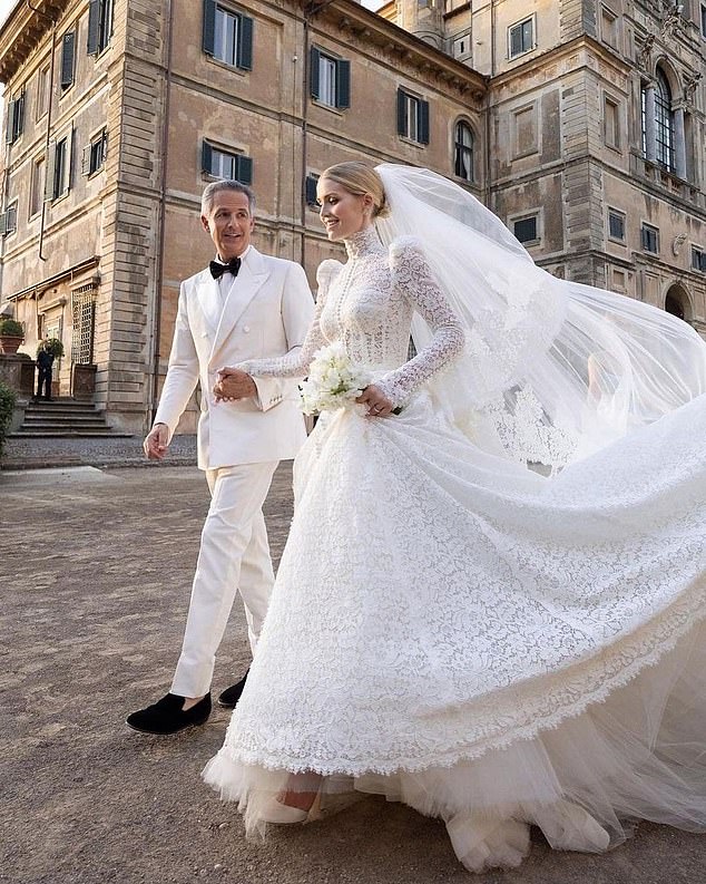 For her main wedding dress, Kitty opted for a Victorian-inspired white lace gown, featuring a high neck, feminine puffed sleeves and a cinched waist.