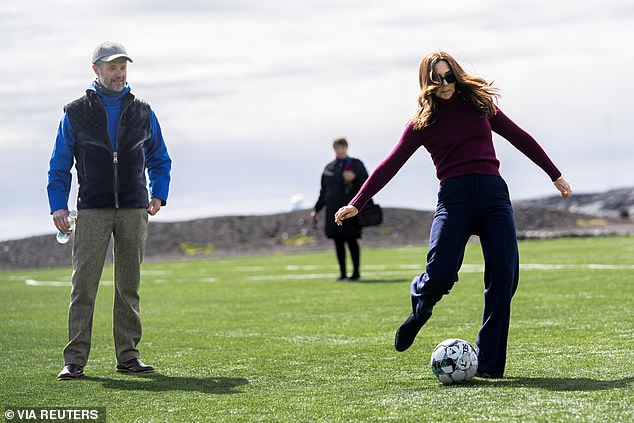 The 52-year-old Australian-born queen showed off her sporting side during her trip to Greenland, playing football.