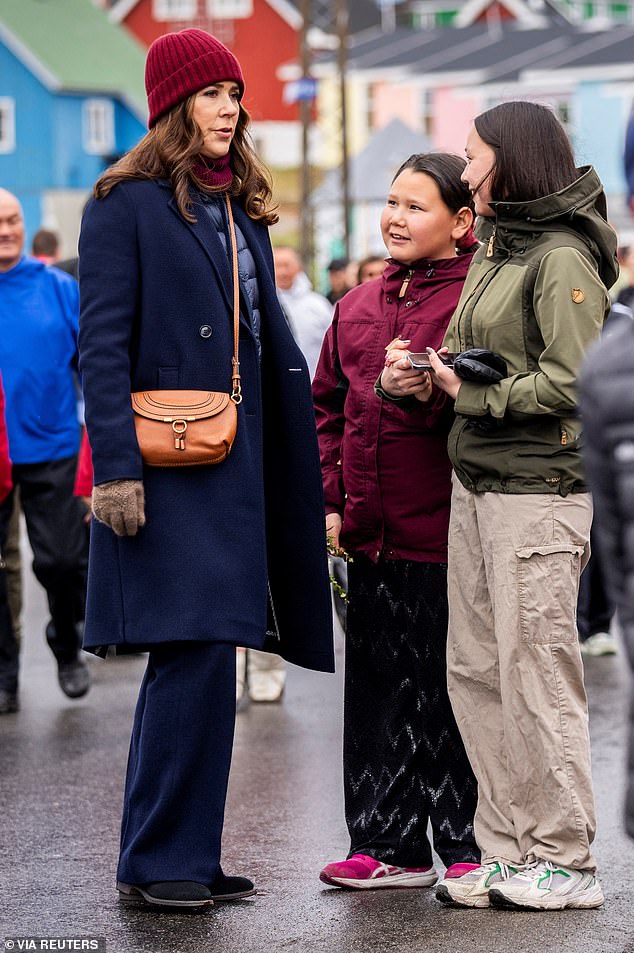 Queen Mary looked cheerful as she chatted to local young people in Qeqertarsuaq in Greenland.