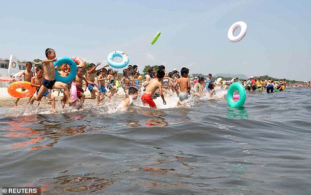 In this undated photo released by the Korean Central News Agency, schoolchildren play in the water at the Songdowon International Children's Camp in the city of Wonsan, North Korea.