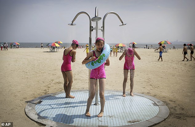 North Korean girls wearing similar swimsuits stand under a shower at the Songdowon International Children's Camp, Tuesday, July 29, 2014, in Wonsan, North Korea