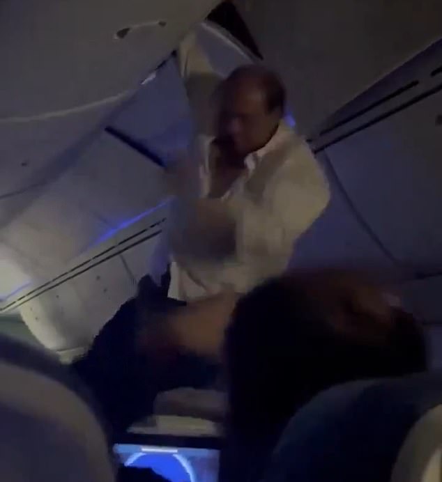 A male passenger is helped out of the overhead bin after being ejected from his seat following turbulence on an Air Europa flight from Spain to Uruguay.