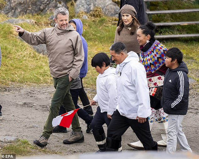 The Danish royal couple were accompanied by the president of the village council, Per Ole Frederiksen (pictured: CL) and Karen Alaufesen (pictured: CR), who grew up in the town.