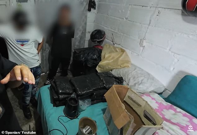 Suspected drug dealers in Medellin, Colombia, are seen standing next to huge bricks of drugs they have just packaged for sale