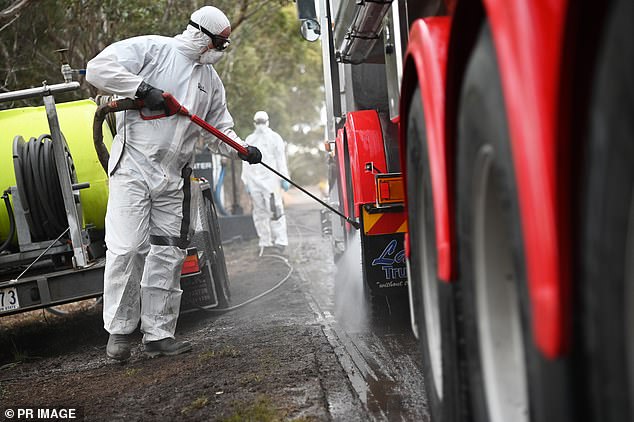 Workers in hazmat suits clean a truck in a quarantine zone after an outbreak of bird flu in Victoria