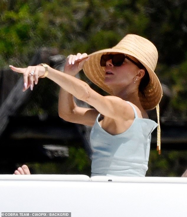 Meanwhile, Victoria, 50, remained on board, relaxing on deck in a chic summer dress and wide-brimmed hat.