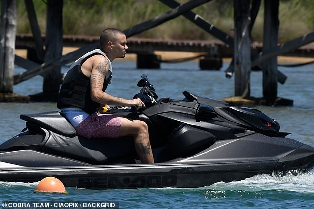 Romeo was seen riding a jet ski and wearing a purple printed swimsuit.