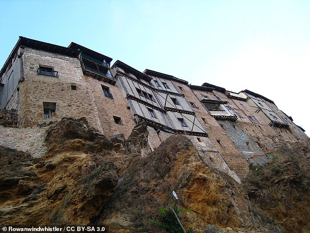 The image shows striking houses hanging from vertical rock walls. Image courtesy of Creative Commons