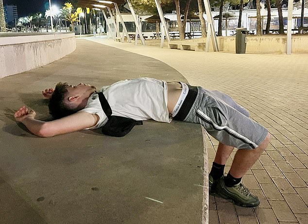 Pictured: A party-goer is seen passed out on a step on the main avenue.