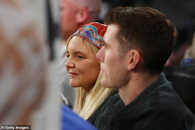 The singer left her long blonde hair loose and accessorized with a colorful scarf as she sat courtside.