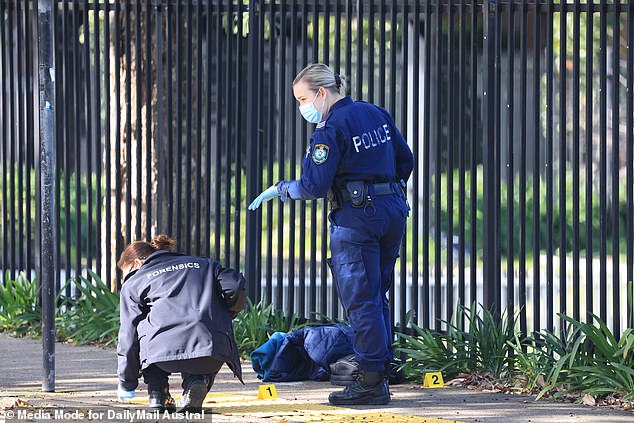 Forensic experts are seen searching the university entrance for clues on Tuesday.