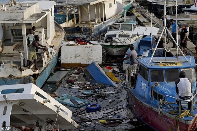 A fisherman throws a rope across boats damaged by Hurricane Beryl at Bridgetown Fisheries in Barbados