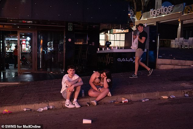 Party-goers can be seen sitting on the pavements with their heads in their hands after a long night of partying in the city.