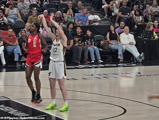 Caitlin Clark shoots a free throw as Mark Davis and his mystery date watch from the court