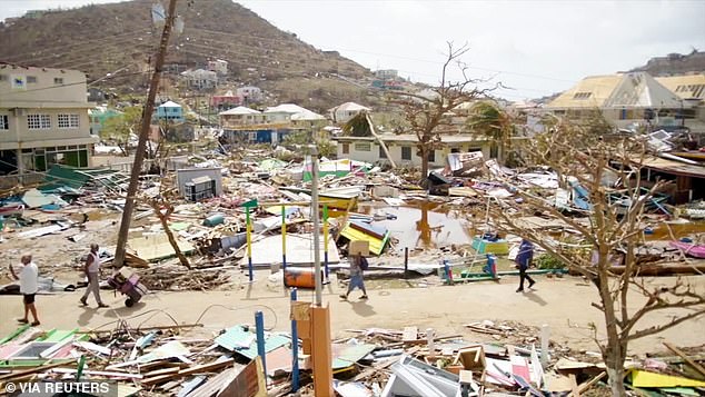 People walk among damaged properties in the aftermath of Hurricane Beryl, on Union Island, Saint Vincent and the Grenadines