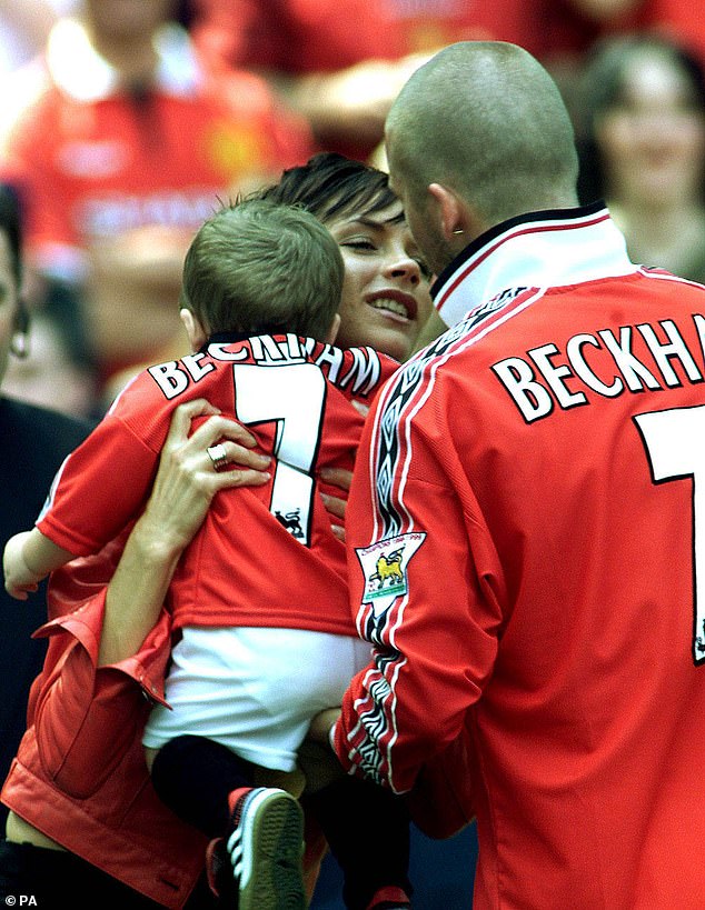 Holding her son Brooklyn, Victoria gives David a kiss after he helped her team win the Premier League title at Old Trafford, Manchester, in May 2000.