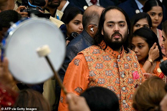 Anant Ambani, 29, pictured at the event, wore an orange beaded Nehru jacket with a kurta underneath.