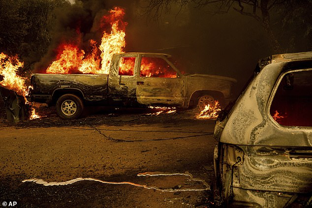 Flames consume vehicles on Bessie Lane as the Thompson Fire burns in Oroville, California, Tuesday, July 2.