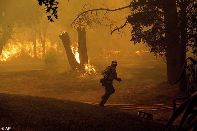 A firefighter runs as he battles the Thompson Fire burning in Oroville, California, on Tuesday.