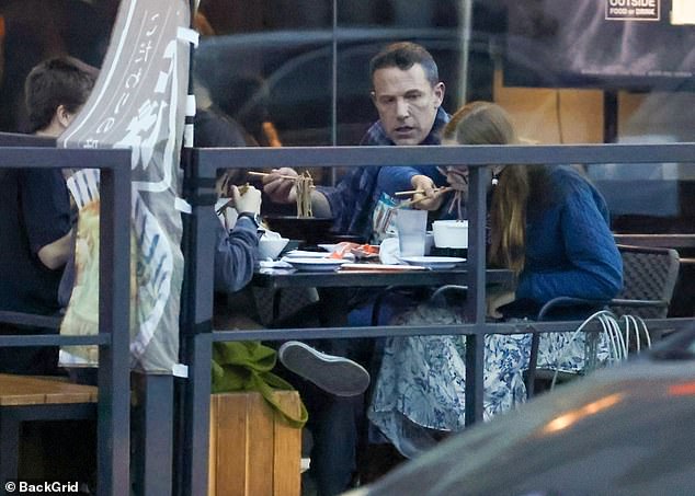 The family enjoyed noodles while eating outdoors.