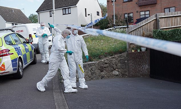 A forensic team passes under police tape cordoning off the scene of the double murder.