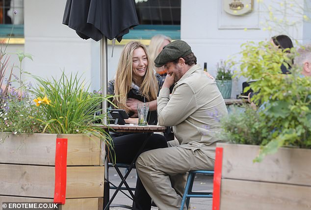 The two appeared to be deep in discussion as they enjoyed a drink outdoors.