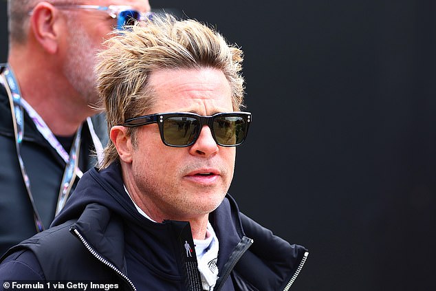 Brad donned a cool pair of sunglasses and wore a navy jacket to keep warm.