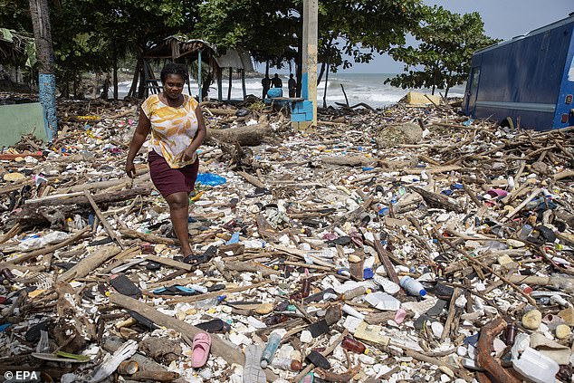 A woman walks on Manresa beach, covered in garbage after the passage of Hurricane Beryl in Santo Domingo, Dominican Republic, July 3, 2024