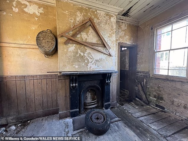 The former train station has been empty for decades, but could now be converted into a modern home. Pictured: one of the station's rooms equipped with a marble fireplace