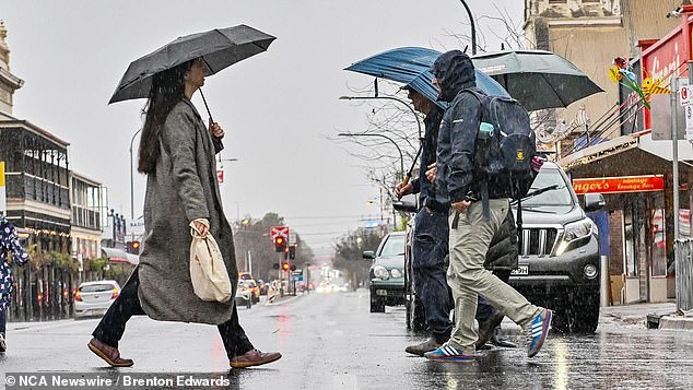 Sydney and Brisbane are set to be the rainiest capitals over the coming days, with showers expected throughout the weekend and early next week. Pictured are people with umbrellas